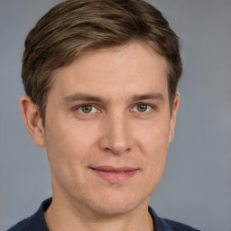 Joyful white young-adult male with short  brown hair and grey eyes