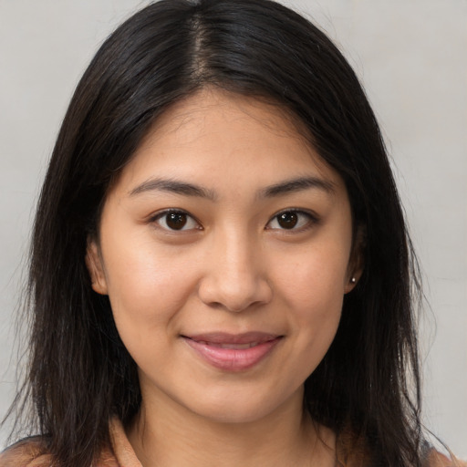 Joyful latino young-adult female with long  brown hair and brown eyes