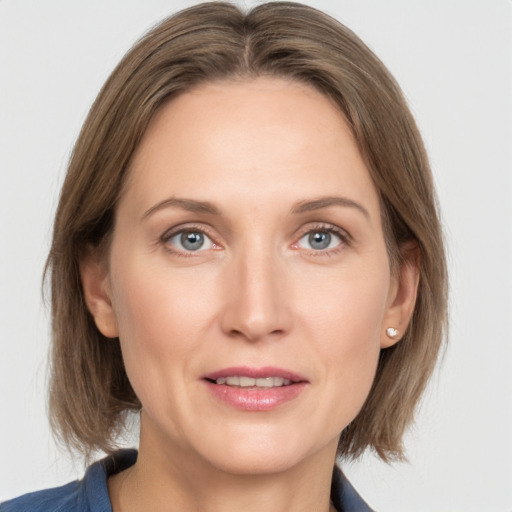 Joyful white adult female with medium  brown hair and grey eyes