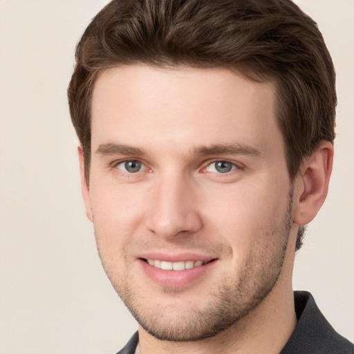 Joyful white young-adult male with short  brown hair and grey eyes