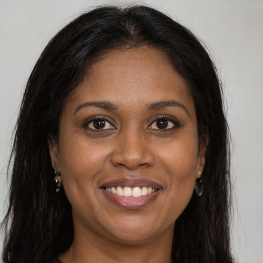 Joyful black young-adult female with long  brown hair and brown eyes