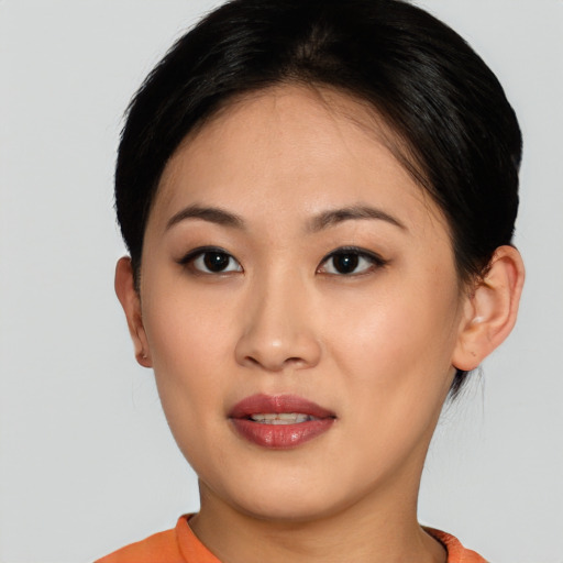 Joyful asian young-adult female with short  brown hair and brown eyes