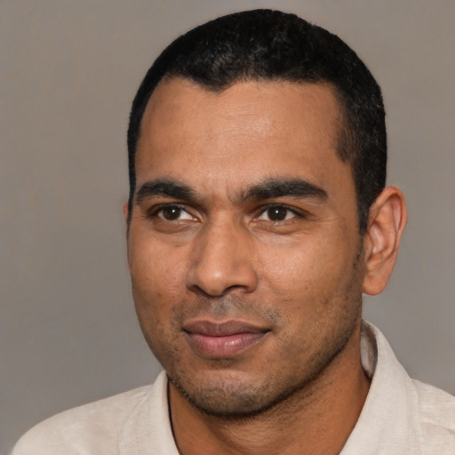 Joyful latino young-adult male with short  black hair and brown eyes