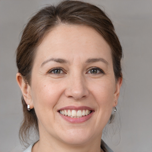 Joyful white adult female with medium  brown hair and grey eyes