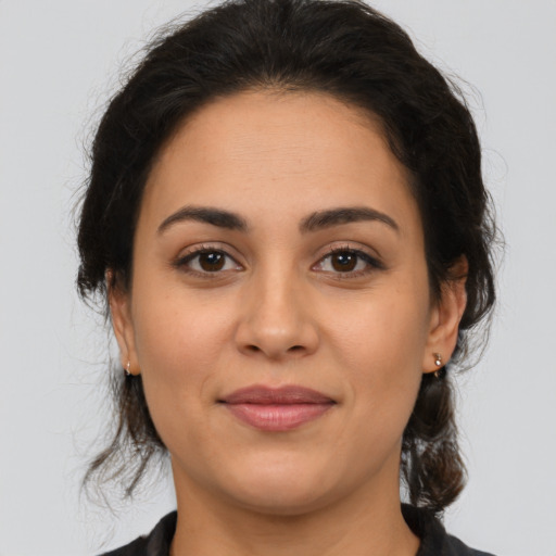 Joyful latino young-adult female with medium  brown hair and brown eyes