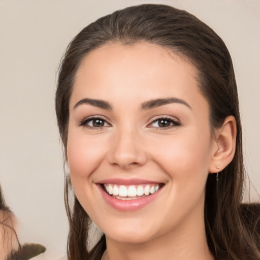 Joyful white young-adult female with long  brown hair and brown eyes