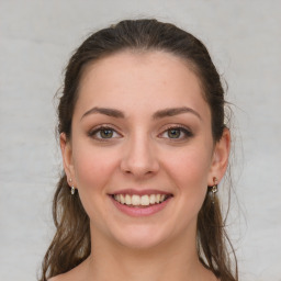 Joyful white young-adult female with medium  brown hair and grey eyes