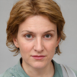 Joyful white adult female with medium  brown hair and blue eyes