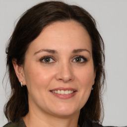 Joyful white adult female with medium  brown hair and brown eyes