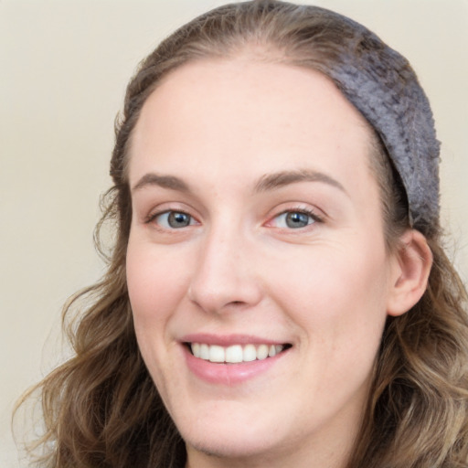 Joyful white young-adult female with long  brown hair and blue eyes