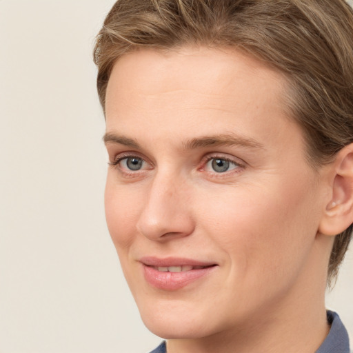 Joyful white young-adult female with short  brown hair and grey eyes