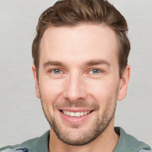 Joyful white young-adult male with short  brown hair and grey eyes