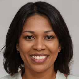 Joyful black young-adult female with medium  brown hair and brown eyes