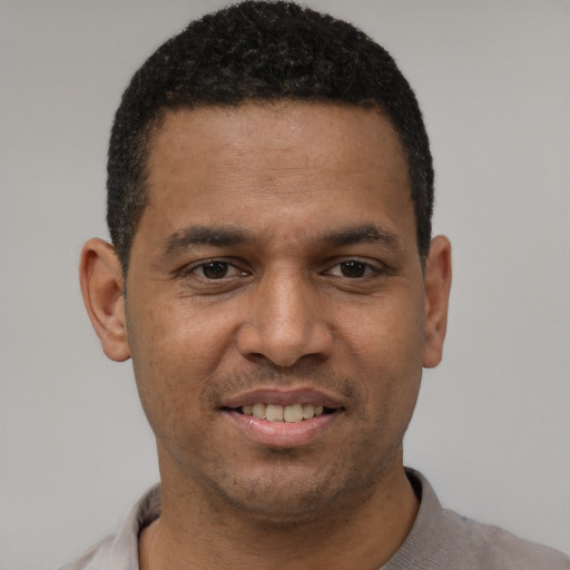 Joyful latino young-adult male with short  black hair and brown eyes