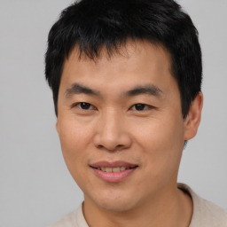 Joyful asian young-adult male with short  black hair and brown eyes