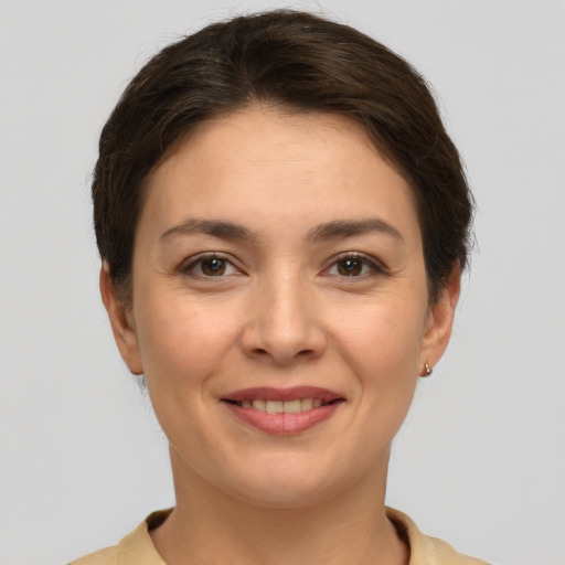 Joyful white young-adult female with short  brown hair and brown eyes