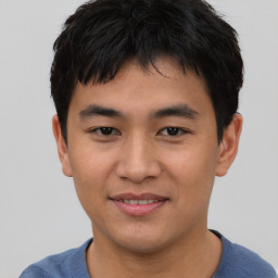 Joyful asian young-adult male with short  brown hair and brown eyes