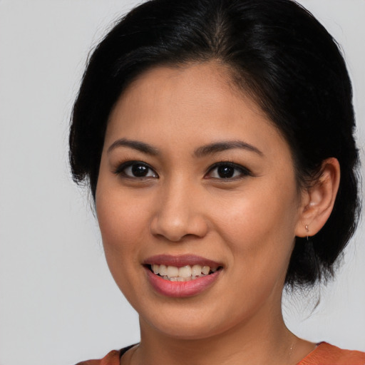 Joyful latino young-adult female with medium  brown hair and brown eyes