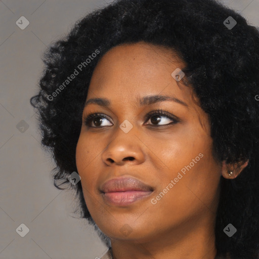 Joyful black young-adult female with long  black hair and brown eyes