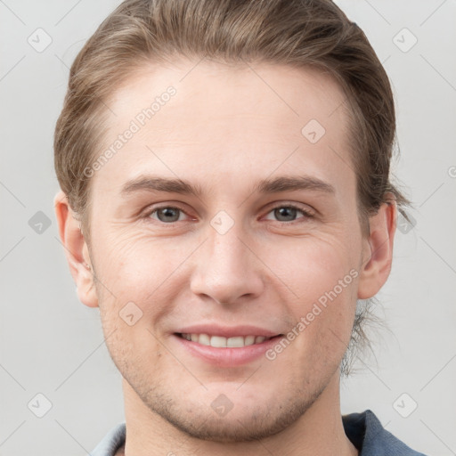 Joyful white young-adult male with short  brown hair and grey eyes