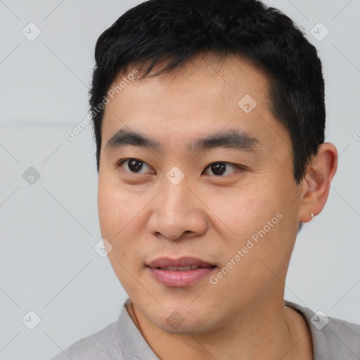 Joyful asian young-adult male with short  black hair and brown eyes