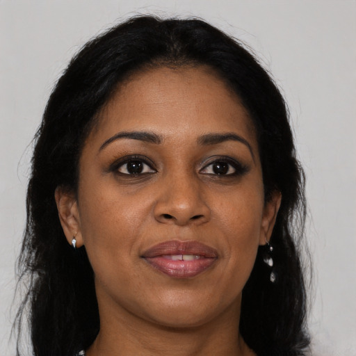Joyful black young-adult female with long  brown hair and brown eyes