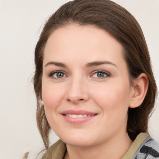 Joyful white young-adult female with medium  brown hair and grey eyes