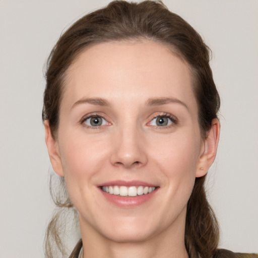 Joyful white young-adult female with medium  brown hair and grey eyes