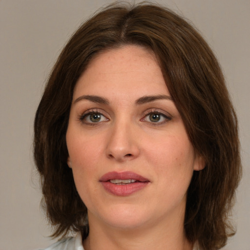 Joyful white young-adult female with medium  brown hair and green eyes