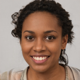 Joyful black young-adult female with long  brown hair and brown eyes