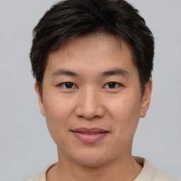 Joyful asian young-adult male with short  brown hair and brown eyes