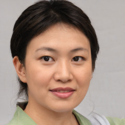 Joyful asian young-adult female with medium  brown hair and brown eyes