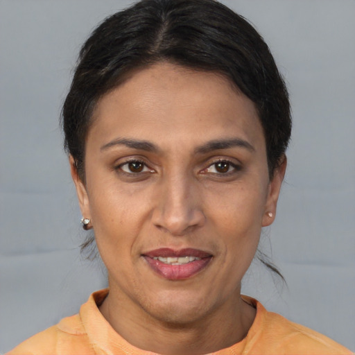 Joyful latino adult female with short  brown hair and brown eyes