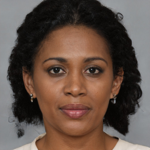 Joyful black adult female with medium  brown hair and brown eyes