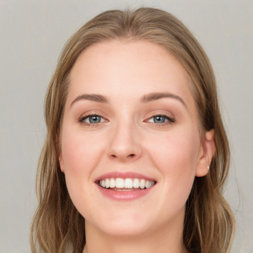 Joyful white young-adult female with long  brown hair and blue eyes