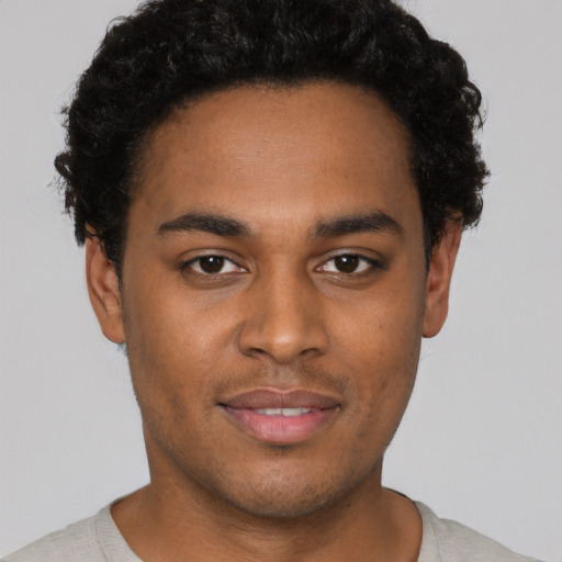 Joyful black young-adult male with short  black hair and brown eyes