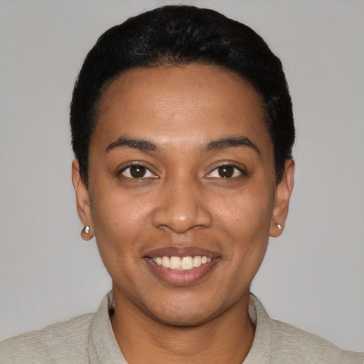 Joyful black young-adult female with short  black hair and brown eyes