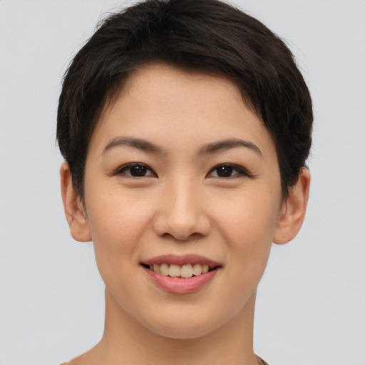 Joyful asian young-adult female with short  brown hair and brown eyes