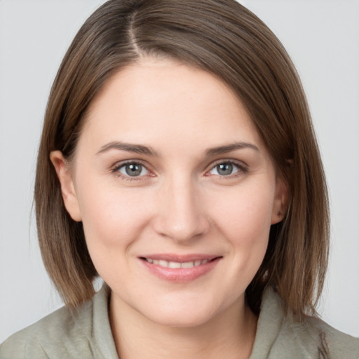 Joyful white young-adult female with medium  brown hair and grey eyes