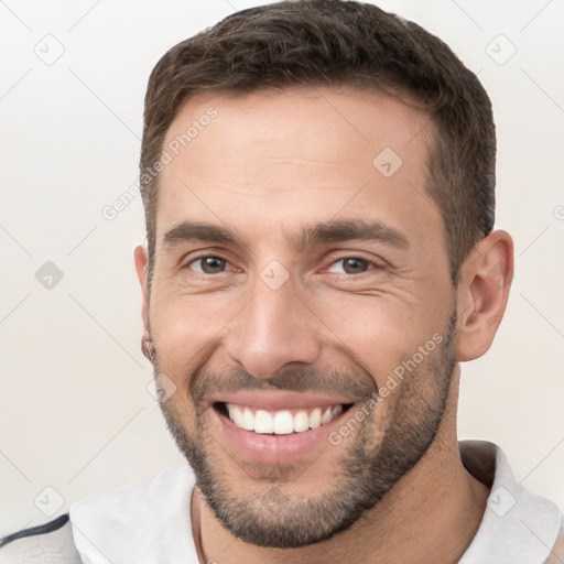 Joyful white young-adult male with short  brown hair and brown eyes