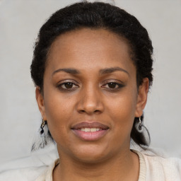Joyful black young-adult female with short  black hair and brown eyes