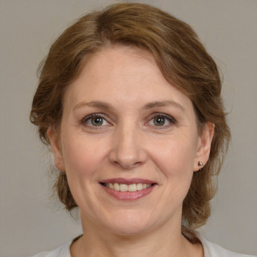 Joyful white adult female with medium  brown hair and grey eyes