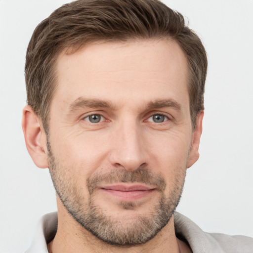 Joyful white adult male with short  brown hair and grey eyes