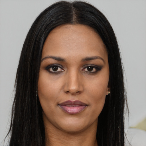 Joyful black young-adult female with long  brown hair and brown eyes