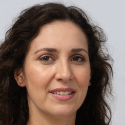 Joyful white adult female with long  brown hair and brown eyes