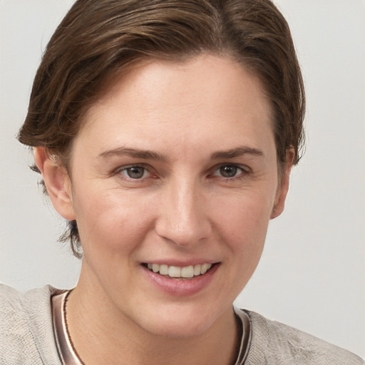 Joyful white young-adult female with short  brown hair and grey eyes