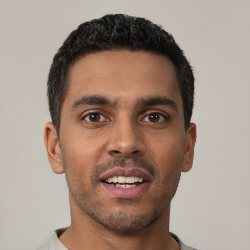 Joyful latino young-adult male with short  black hair and brown eyes
