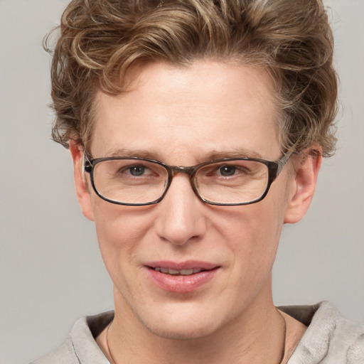 Joyful white adult male with short  brown hair and blue eyes