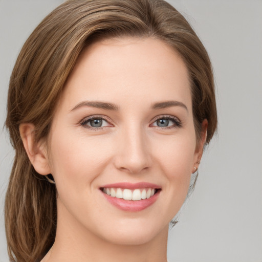 Joyful white young-adult female with long  brown hair and grey eyes