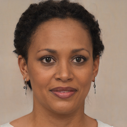 Joyful black adult female with short  brown hair and brown eyes